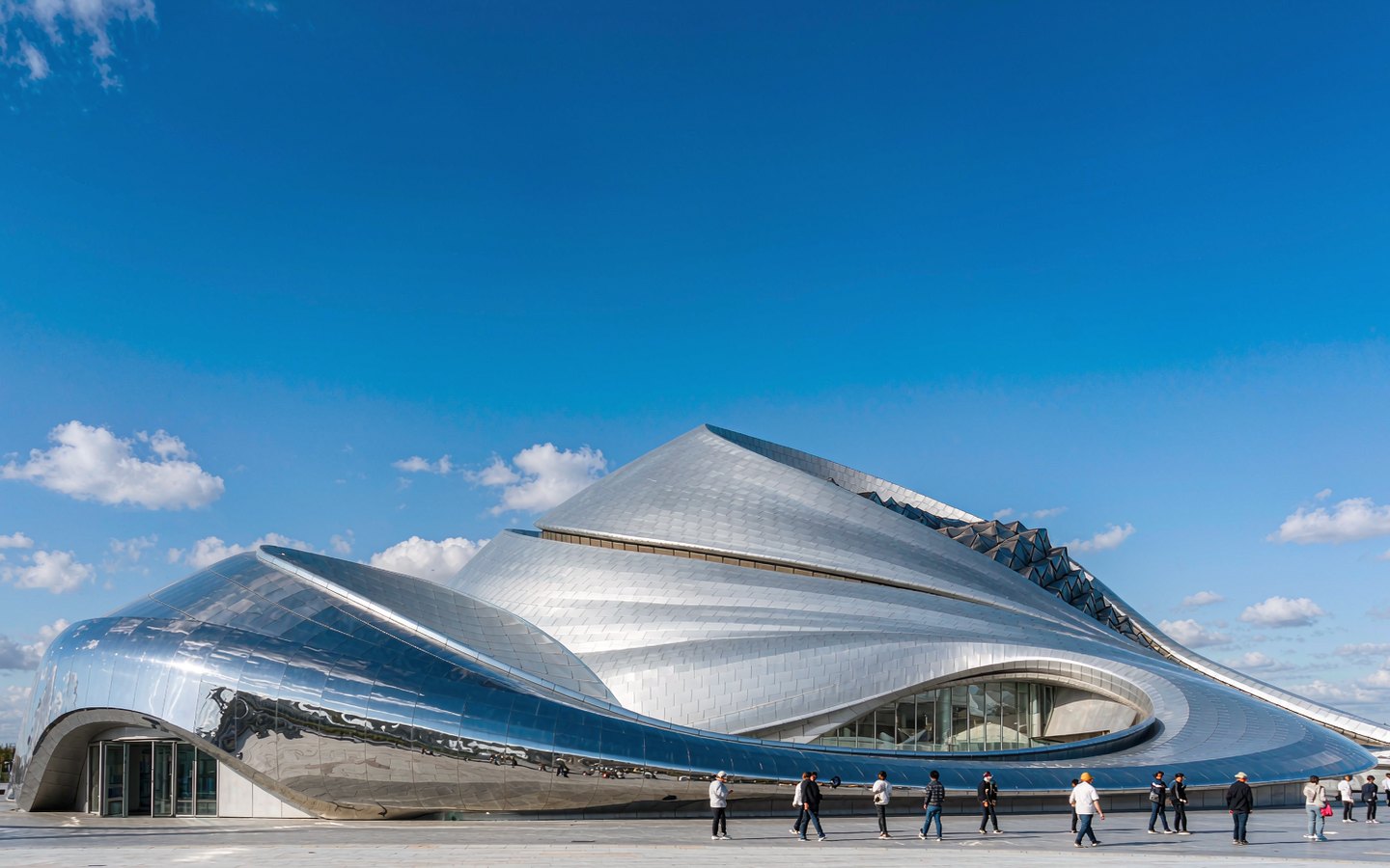 Sweeping steel curves of a futuristic museum under a blue sky