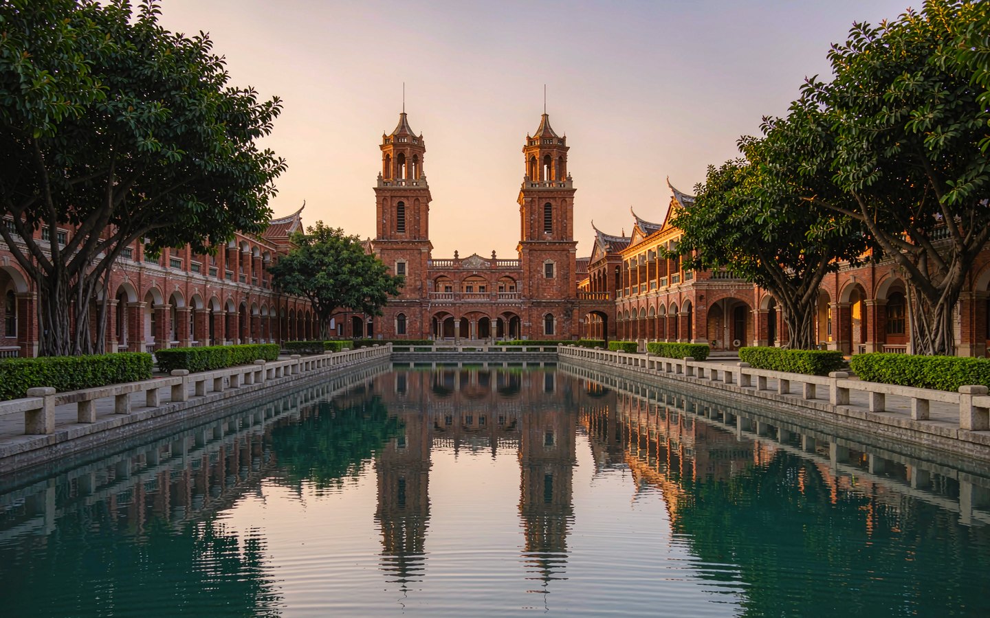 Red-brick tower with swallow-tail roof ridges above a tidal pool