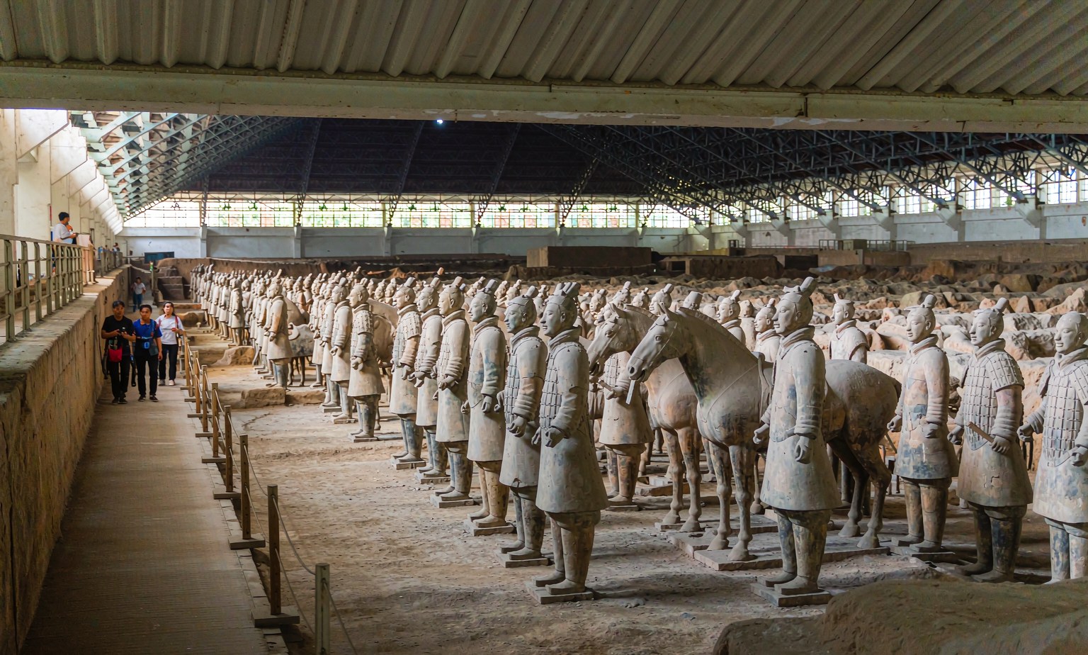 Rows of life-size Terracotta Army warriors and a horse inside the excavation hall near Xian