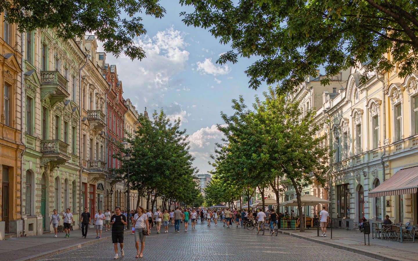 Summer sun on the cobbles of Central Street, Harbin, European facades under full green trees