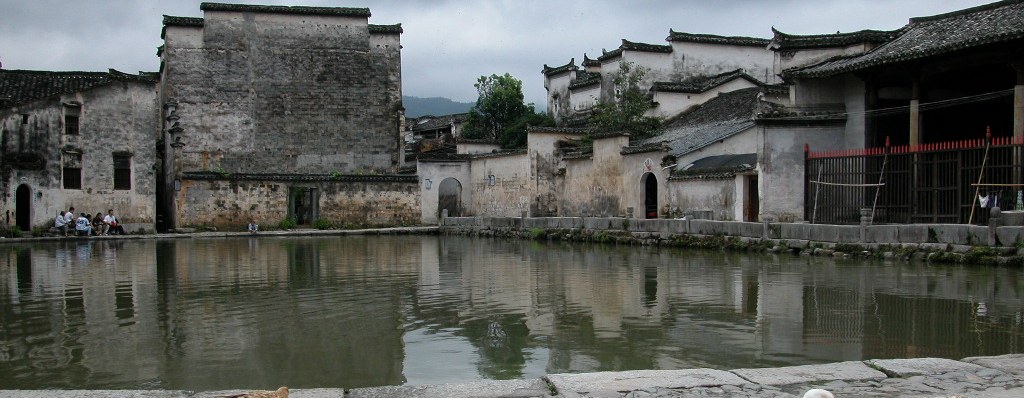 Geese on the stone quay of Hongcun's pond under dark clouds