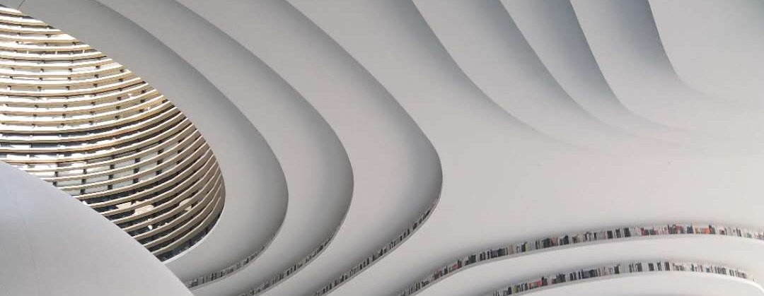 The white terraced book-mountain inside Binhai Library with readers on its curved steps